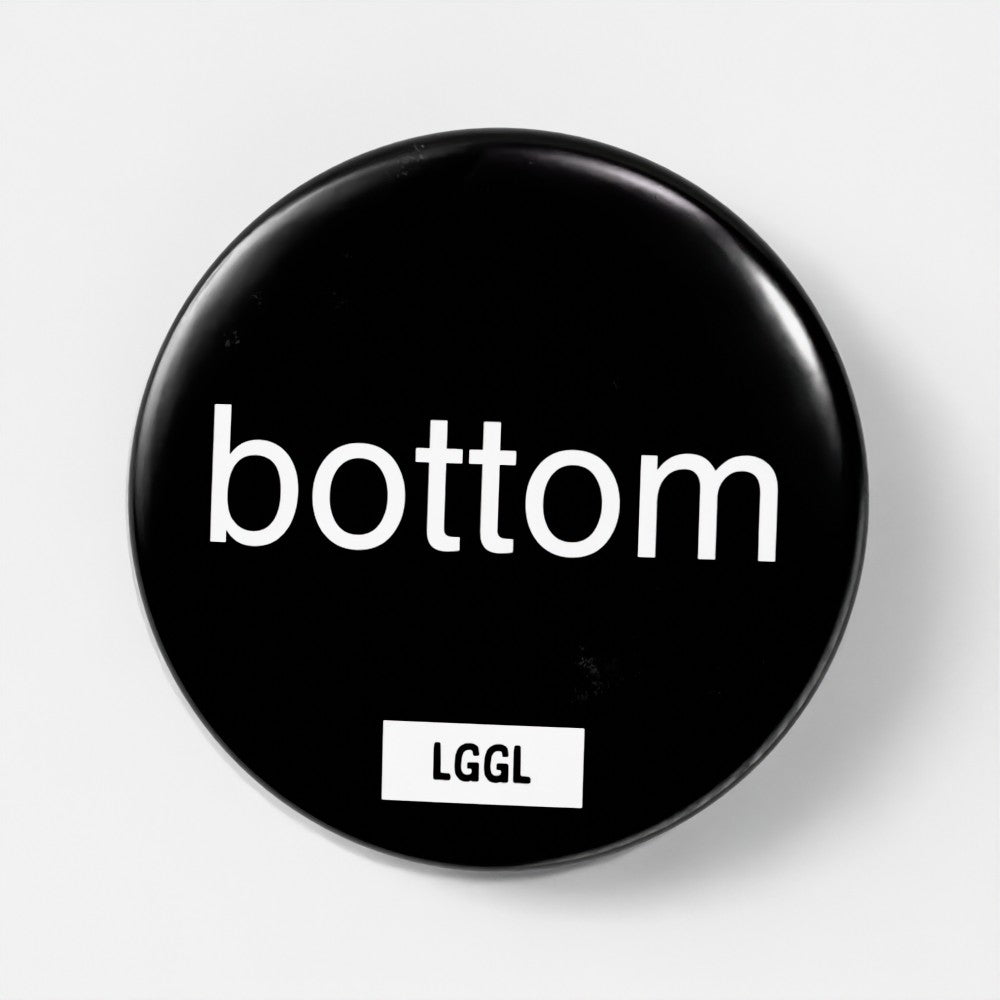 Black round kinky pin badge with "bottom" text
