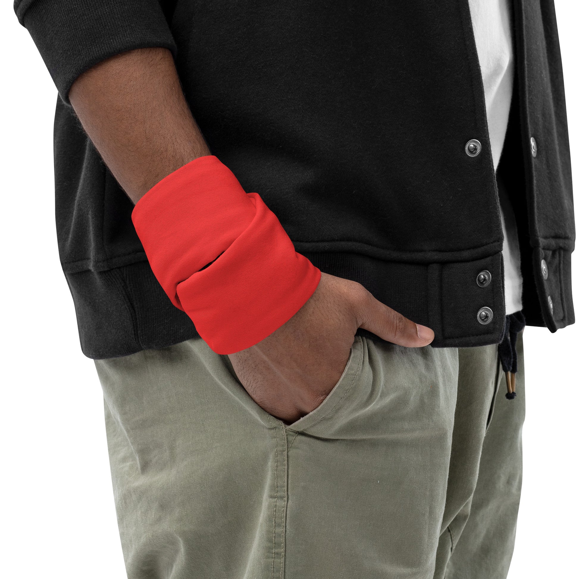 Person wearing a black jacket with red sleeve and beige pants on a white background