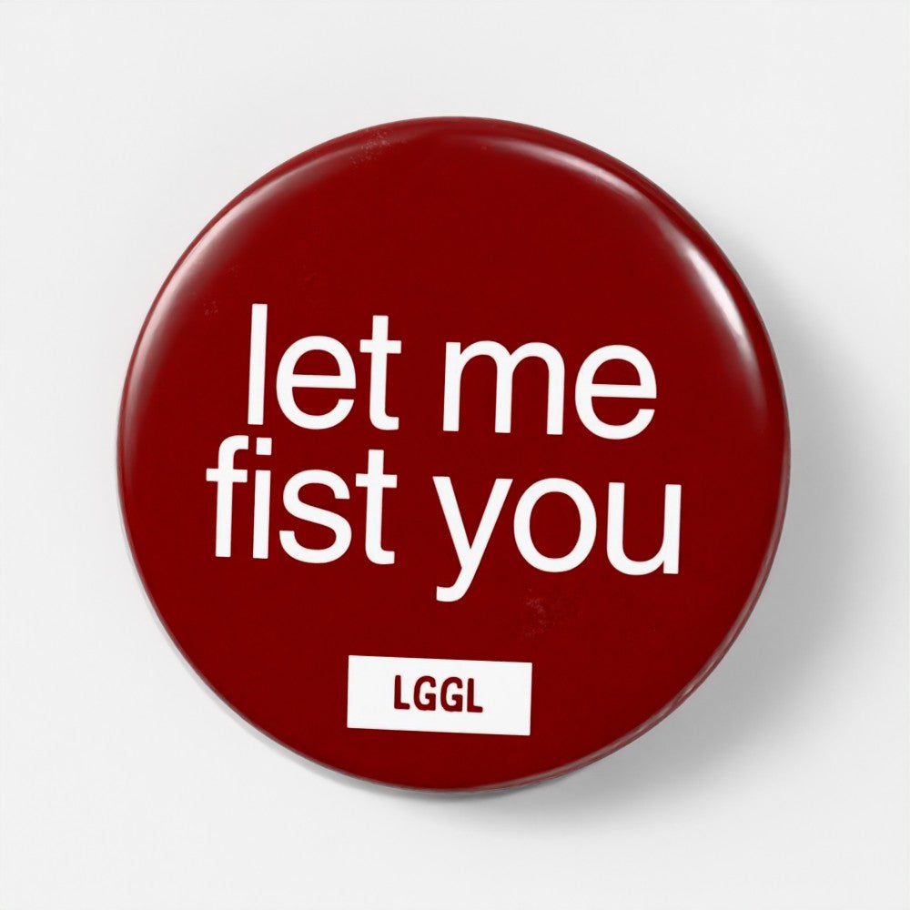 Round pin badge for gay men with "let me fist you" text