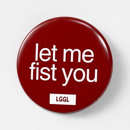 Round pin badge for gay men with "let me fist you" text
