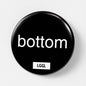 Black round kinky pin badge with "bottom" text
