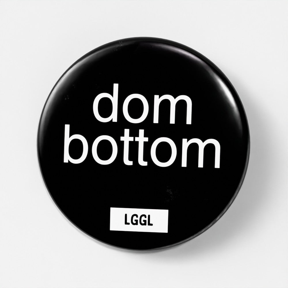 Round pinback button showing "dom bottom" text