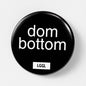 Round pinback button showing "dom bottom" text