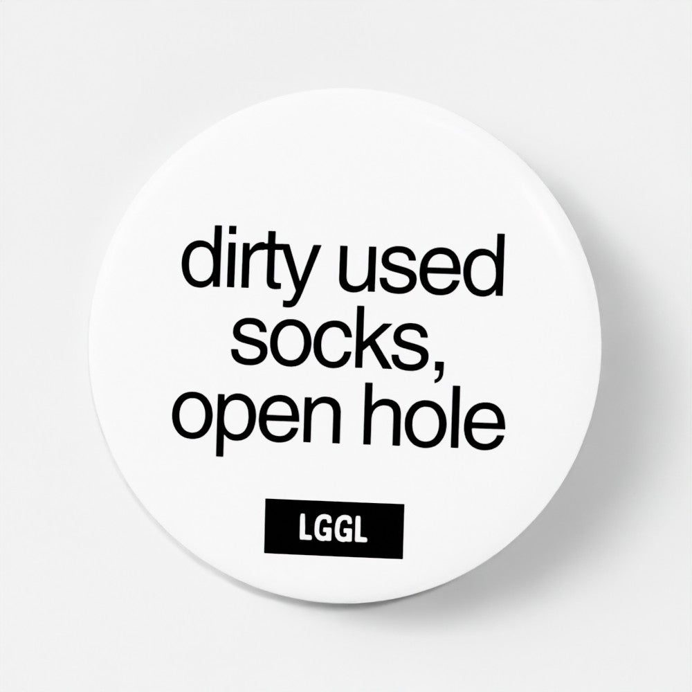 A pin badge featuring a statement about used dirty socks and feet worship