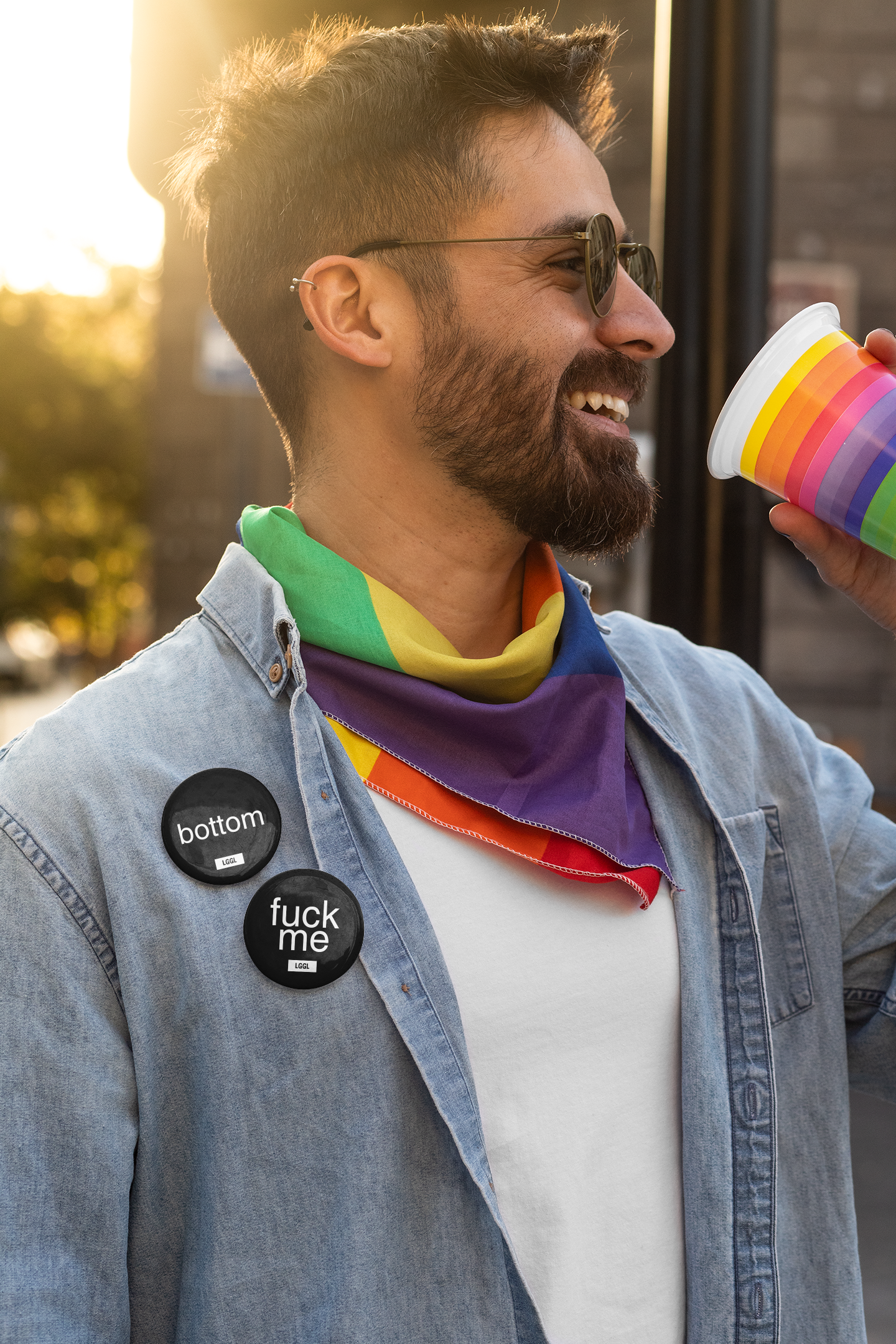 A happy man celebrating gay pride wearing two pin badges
