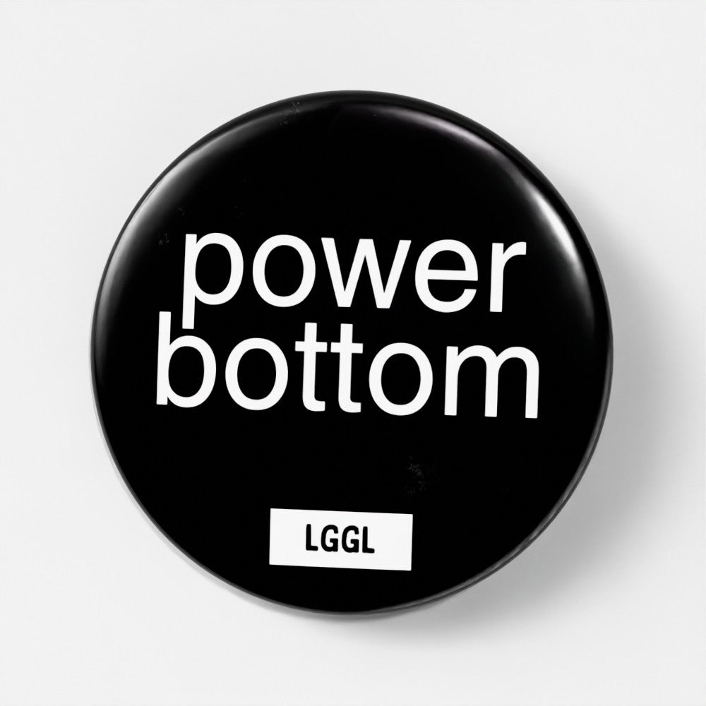 "Power bottom" written on a large black pin badge