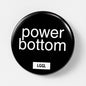 "Power bottom" written on a large black pin badge